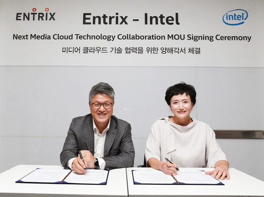 이재환 엔트릭스 대표(왼쪽)와 권명숙 인텔코리아 사장이 미디어 클라우드 기술 협력을 위한 협약서에 사인하고 있다.    SK텔레콤 제공